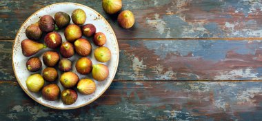 Ahşap arka plan bir tabağa incir