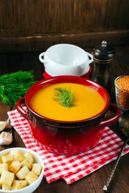 Mercimek çorbası, kırmızı seramik tencere, ahşap arka plan, baklagiller, pişirme ev