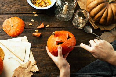 Kabak bir Cadılar Bayramı partisi, rustik tarzı, ahşap arka plan için bir bıçak yüz ile teslim, eller