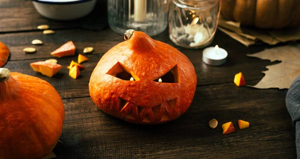 Preparing for the holiday Halloween, pumpkin, cut face, candles, wooden background