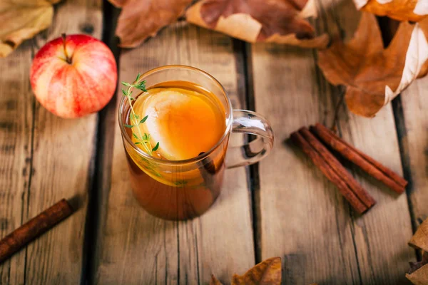 Apple tea with cinnamon, wooden background, retro rustic style, autumn mood