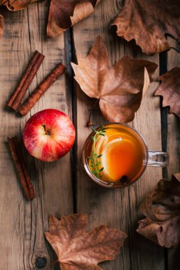 Elma çayı, tarçın, ahşap arka plan, retro rustik tarzı, Sonbahar ruh hali, düşen kuru yapraklar