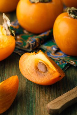 Trabzon hurması, kesim, yeşil ahşap eski arka plan