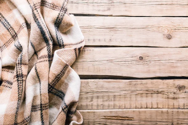 Eski ahşap zemin üzerine ekose yün şal