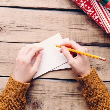 Dostum yazıyor bir mektup, Noel, elinde, kalem kutuları hediyeler, ahşap arka plan, Havva ile