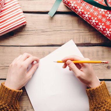 Dostum yazıyor bir mektup, Noel, elinde, kalem kutuları hediyeler, ahşap arka plan, Havva ile
