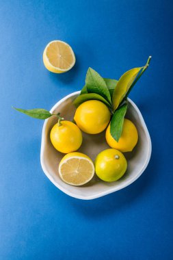 Limon bir seramik tabak bir mavi arka plan, narenciye, C vitamini