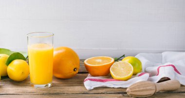 Lezzetli turuncu ve ahşap masa üzerinde meyve sıkacağı ile cam meyve suyu hazırlama