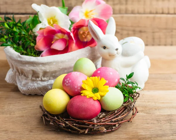 イースター 着色塗装木製の背景に巣卵春のキリスト教の祝日 — ストック写真