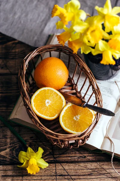 橘子在篮子里 水仙花 质朴的静物 木制的背景 — 图库照片