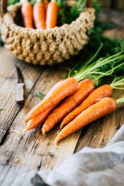 Tahta bir masada saplı taze havuç ve yapraklar, sebze mahsulü