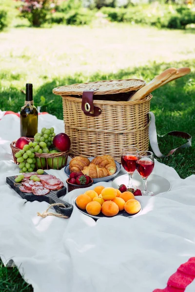 Picnic basket, fruit and wine, summer day in the park