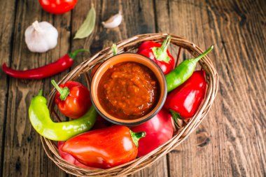 Adjika, baharatlı domates sosu, ahşap bir arka plan üzerinde sebze çerez