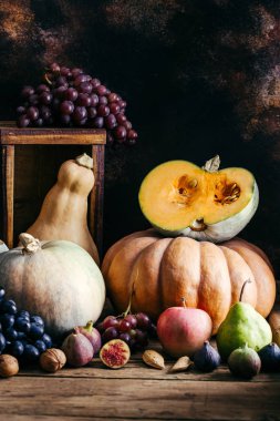 Ahşap bir arka plan üzerinde Sonbahar sebzeler, kabak, üzüm, incir, fındık