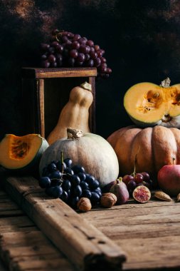 Ahşap bir arka plan üzerinde Sonbahar sebzeler, kabak, üzüm, incir, fındık