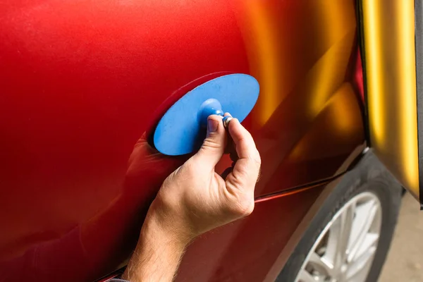 Repairing car dent after the accident by paintless dent repair