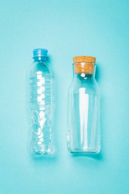 Mavi arka planda su için plastik ve cam şişeler, bir alternatif.