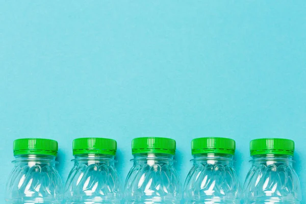 Plastic bottles with green caps on a blue background
