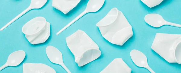 Disposable plastic tableware on a blue background