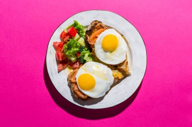 Pembe arka planda iki yumurtadan kızarmış yumurta.