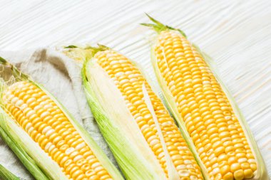 Beyaz ahşap arka planda, koçanda taze mısır.