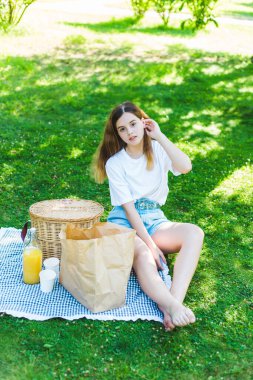 Kız parkta çimlerin üzerinde dinleniyor.