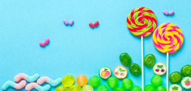 Tatlılar yaratıcı. Mavi arka planda lolipoplar. 