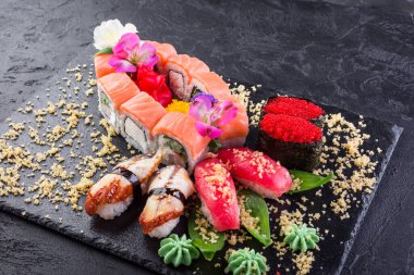 Suşi ve rulo. Çiçeklerle süslenmiş Japon yemekleri.