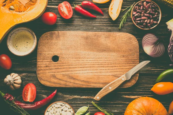 Food Frame. Fresh Vegetables and Cutting Board on a Wooden Background. Copy spice