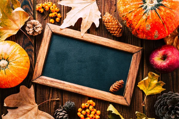 Herfst achtergrond en indeling. Slate board in een frame van pompoen en gele bladeren. Kopieerruimte — Stockfoto