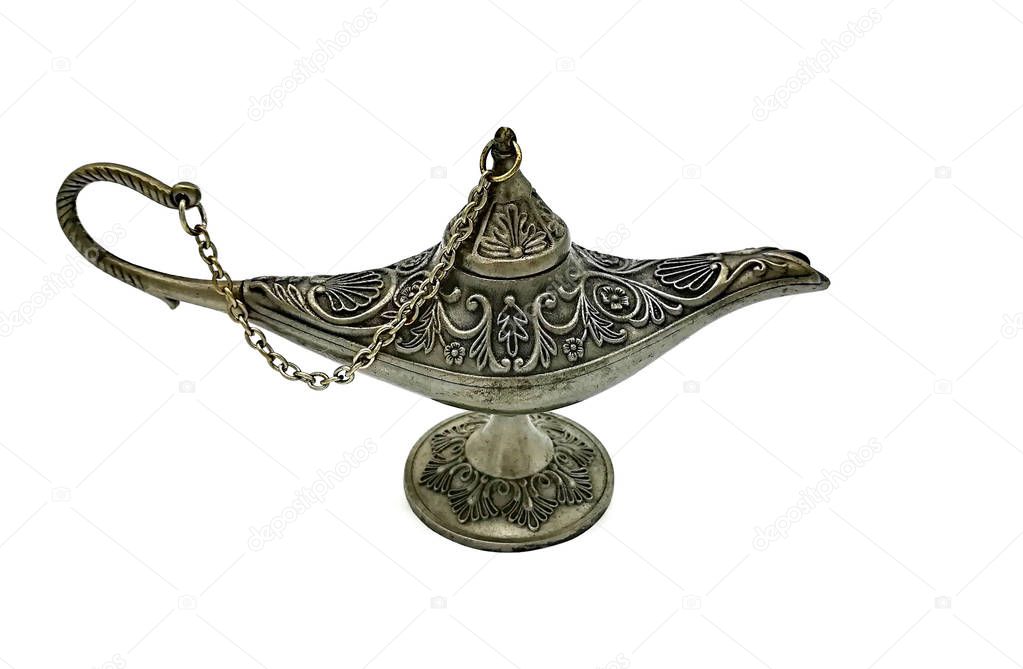 Silver closed Aladdins lamp on a white  background. Ornamental textured old metallic lamp with chain and cap. Antique style.