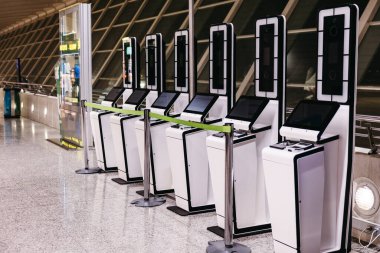 Row of biometric check-in machines at modern airport terminal