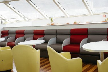 Modern empty seats and tables inside a ferry lounge