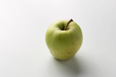Beyaz bir arka planda izole edilmiş yeşil elma olgun ve sulu görünümlerini sağlıklı atıştırmalıklar için ideal hale getiriyor.