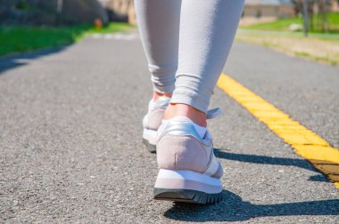 Yürüyüş. Yakın çekim Kadın koşu ayakkabıları döşeli bir iz üzerinde. Kadın spor ayakkabı ayaklarda.