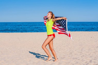 Mutlu bir vatansever güzel kadın ile Amerikan bayrağı Sahilde uzanmış ellerini düzenlenen
