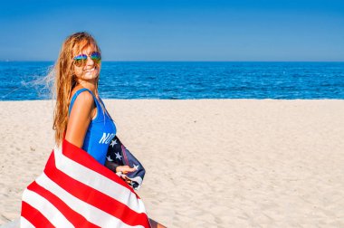 Bir Amerikan bayrağı sahilde tutan güzel neşeli kadın. Seyahat. ABD