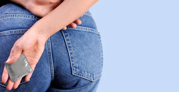 Kadın prezervatif elinde tutuyor. Emniyet konsepti