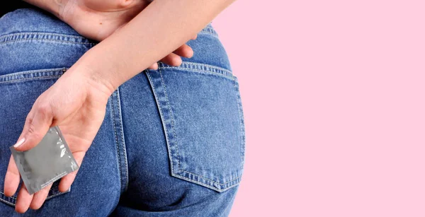 Kadın prezervatif elinde tutuyor. Emniyet konsepti