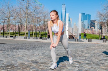 Atletik genç kadın ayakları Çalıştır New York'ta önce germe
