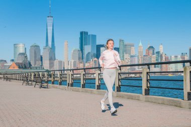 Healthy lifestyle. Woman is running in New York. Fitness sports runner is jogging in  the city clipart