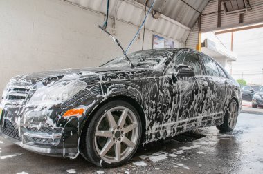 Araba yıkama. Köpük tarafından kaplı modern araba Temizleme.