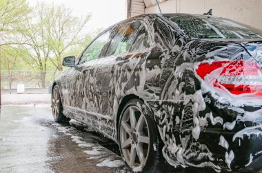 Araba yıkama. Köpük tarafından kaplı modern araba Temizleme.