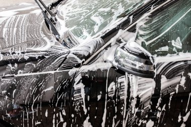 Araba yıkama. Köpük tarafından kaplı modern araba Temizleme.