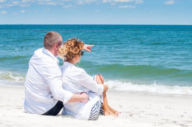 Balayı. Mutlu çift tropik sahilde oturmuş.