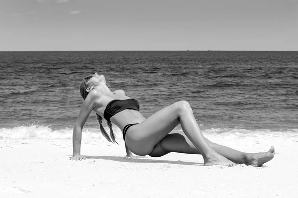 Güzel ince kadın kum üzerinde yalan ve plaj bronzlaşma bikini 