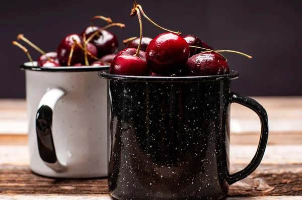 Taze olgun kiraz. Kiraz ahşap masa üzerinde emaye Kupası 
