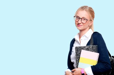 Mutlu genç öğrenci kız kitap, lise ya da üniversite graduand mavi arka plan üzerinde tutarak. Okula dönüş