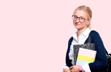 Mutlu genç öğrenci kız kitap, lise ya da üniversite graduand pembe arka plan üzerinde tutarak. Okula dönüş