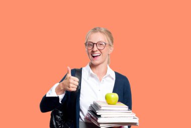 Mutlu genç öğrenci kız kitap, lise ya da yüksekokul graduand renkli arka plan üzerinde tutarak. Okula dönüş